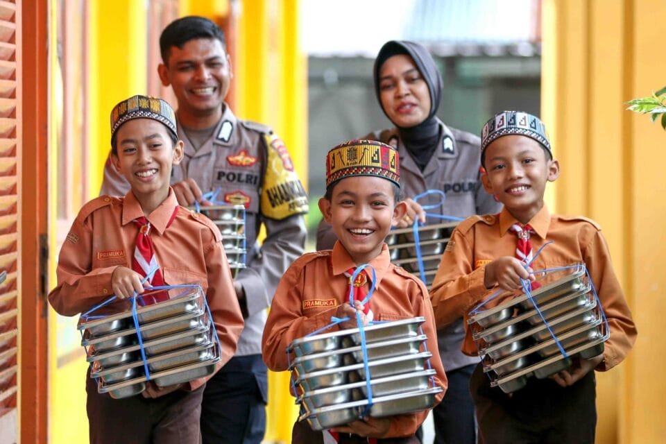 pelajar bersama personel Polresta Banda Aceh membawa menu Makan Bergizi Gratis (MBG) yang telah di uji tim food security Seksi Kedokteran dan Kesehatan (Sidokkes) di SD Negeri 64 Banda Aceh, Aceh, Jumat (31/10/2025). ANTARA FOTO/Irwansyah Putra/indonesia.go.id
