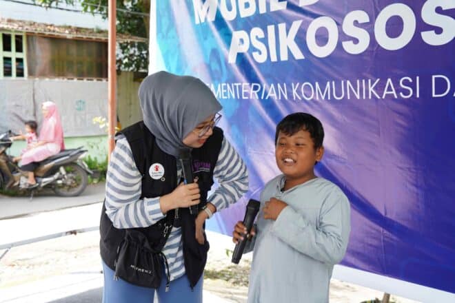 Fasilitator Annisa Asrin dari P3M USU Medan dan relawan Save the Children mengajak anak warga Medan Maimun berdialog di Tenda Dukungan Psikososial KomdigiPeduli di Gg Jawa Komplek Mariana, Kampung Baru, Kecamatan Medan Maimun, Kota Medan, Sumut, Minggu (14/12/2025). (Foto: Djanes Nafi/Dit KPM Kemkomdigi)