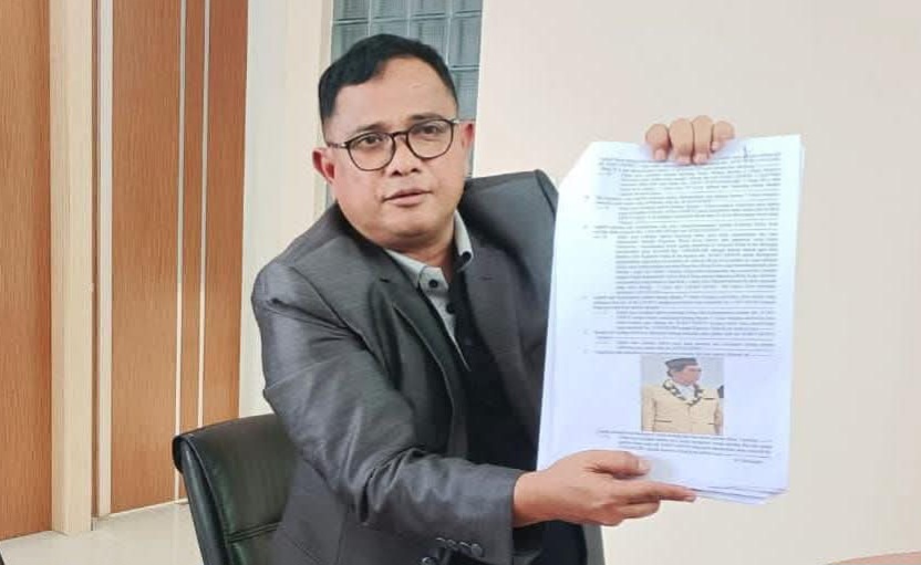 Defense lawyer Asmuni presents a case file containing a photograph of alleged drug lord Koko Erwin and evidence of financial transcripts during a press conference on police corruption in Bima, Indonesia (istimewa)